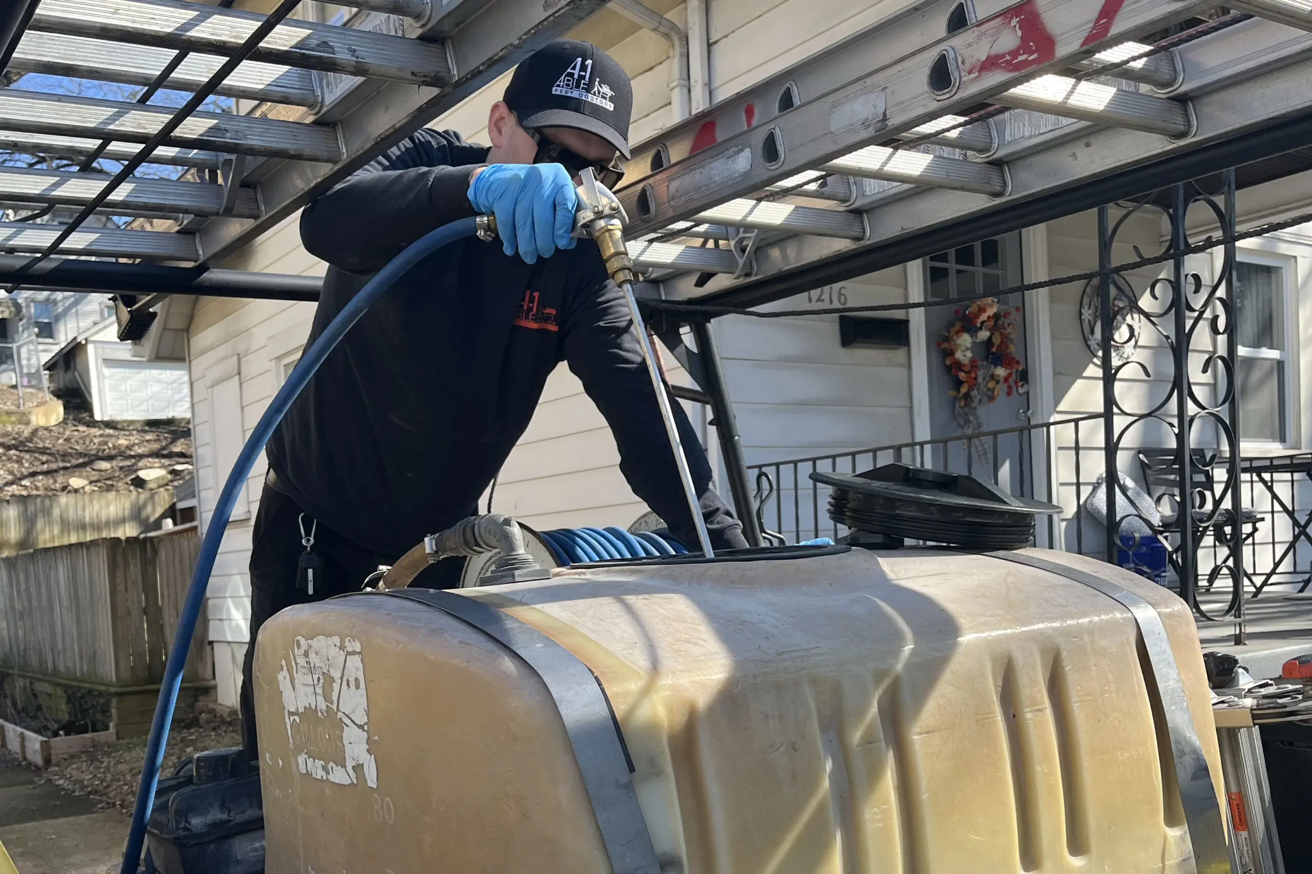 A-1 Able Pest Doctors technician treating a home for termites with specialized equipment.