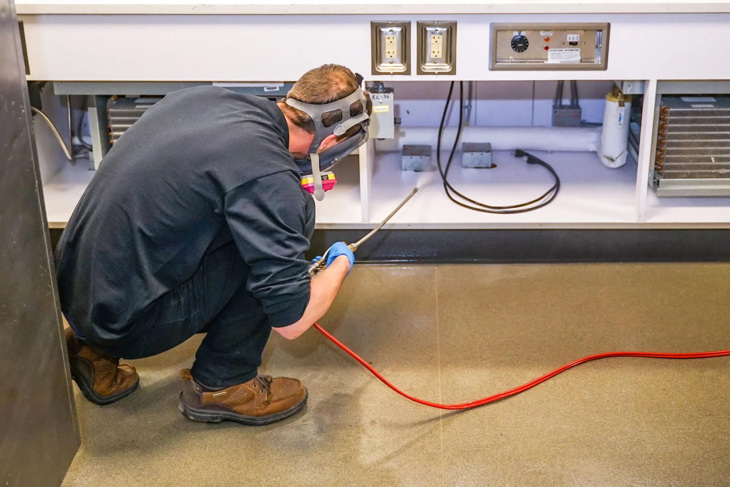 A-1 Able Pest Doctors technician treating for ants inside a commercial property kitchen area.